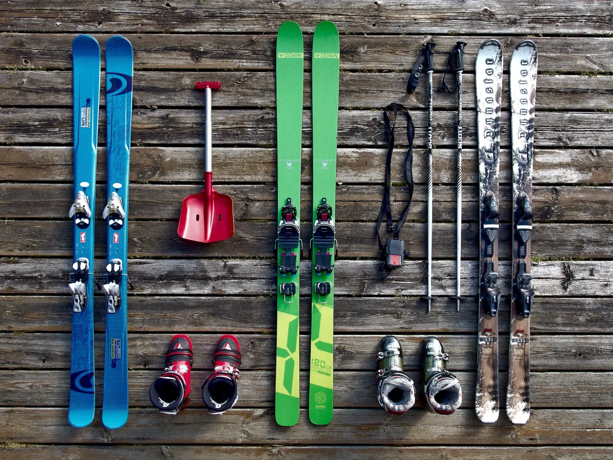 Skis et bâtons alignés contre un mur en bois