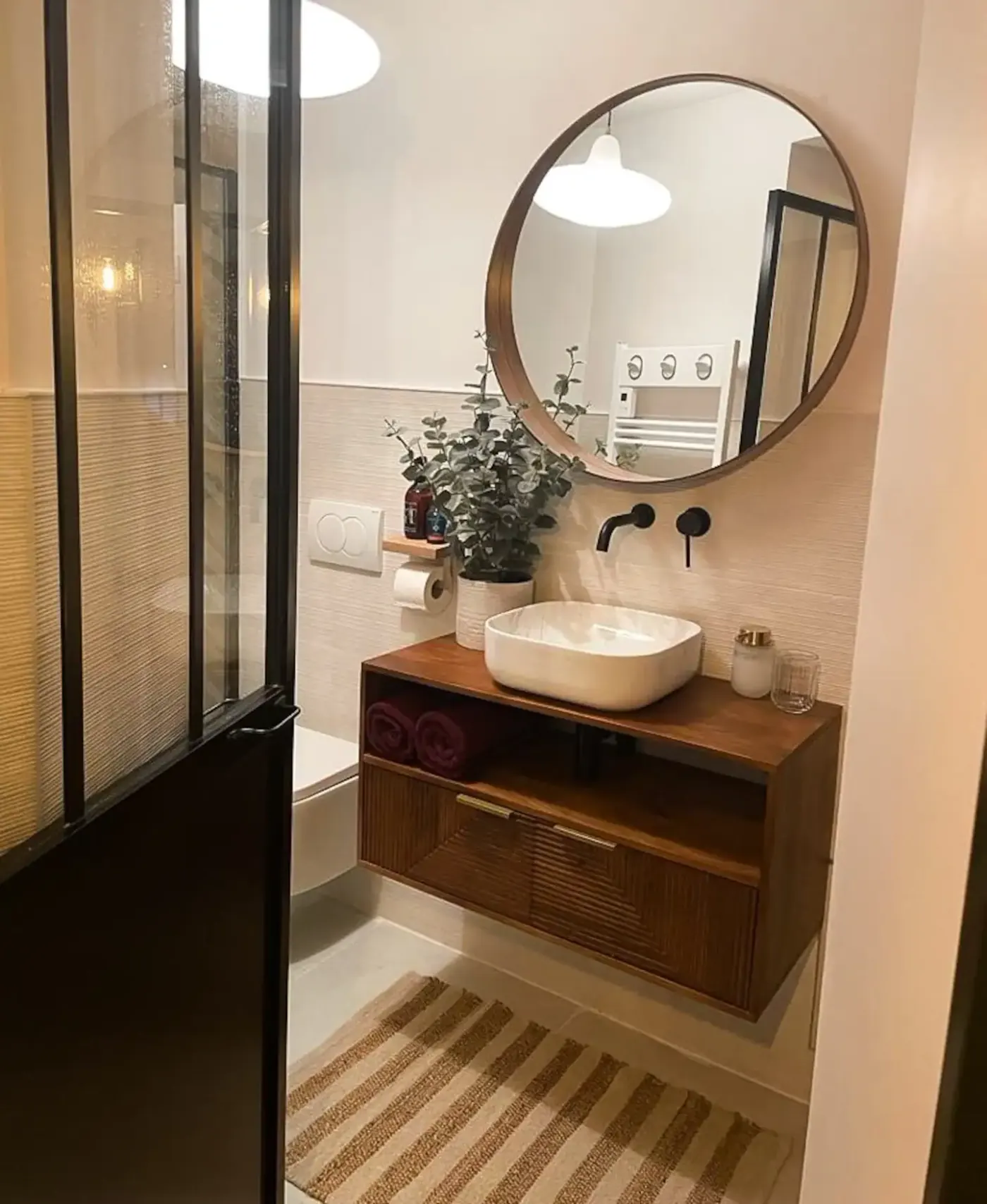 Salle de bain avec vasque en bois et miroir rond