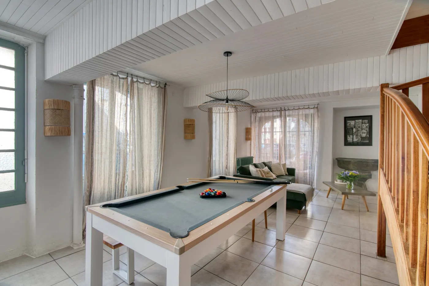 Salle avec billard et grande baie vitrée
