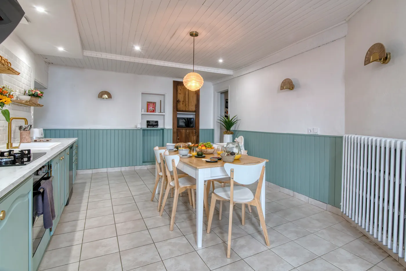 Séjour lumineux avec table à manger et radiateur en fonte